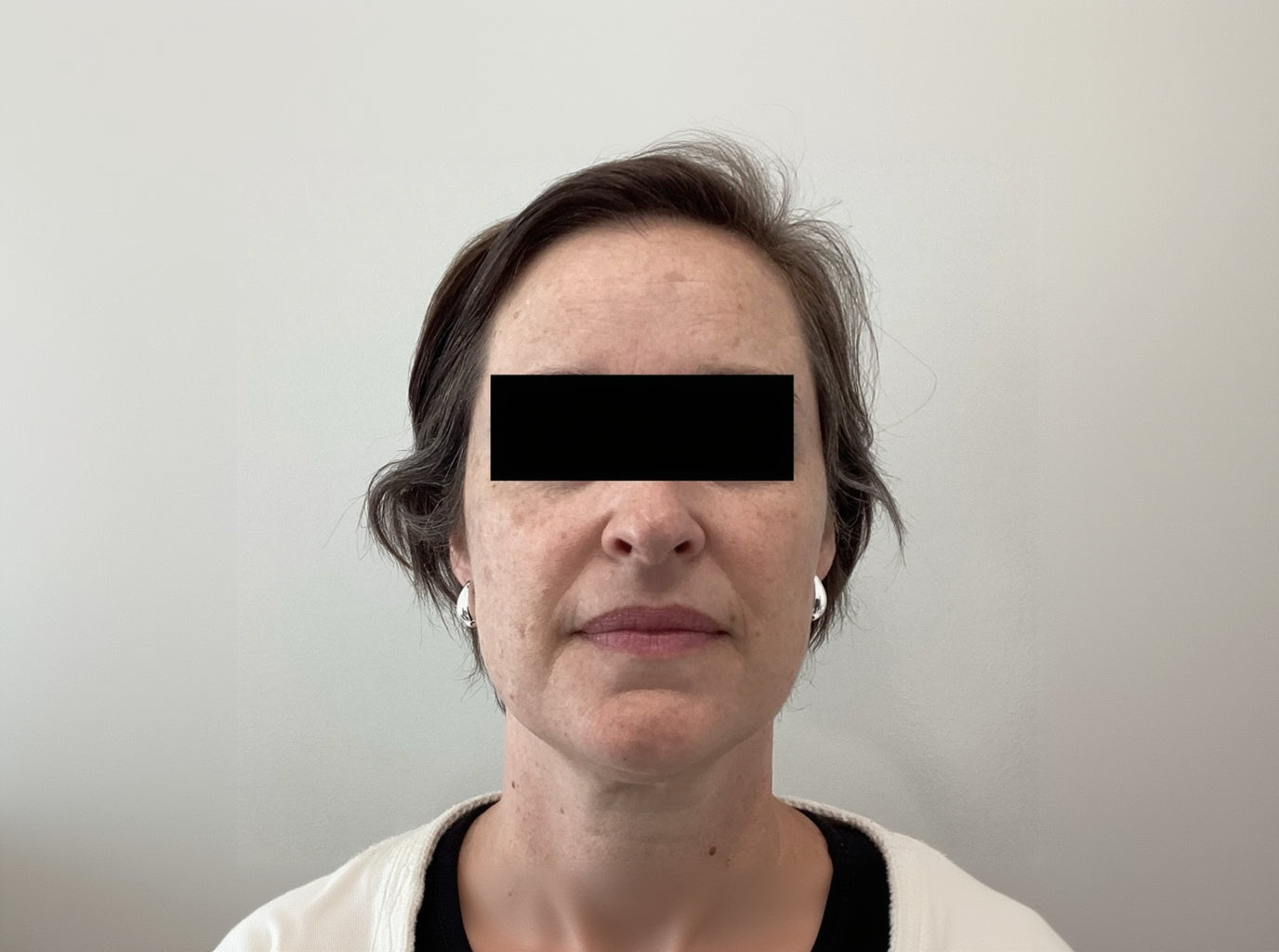 Person with a neutral expression on a plain background