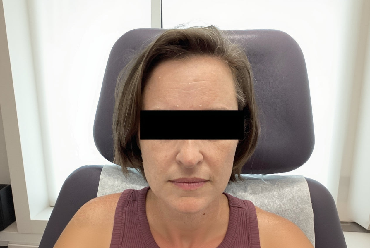 Person sitting in a chair with a black bar over their eyes