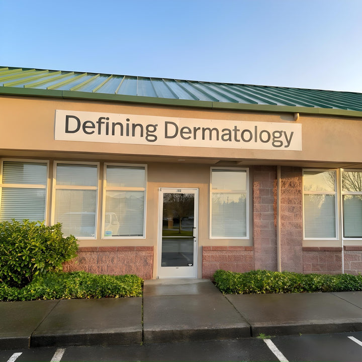 Building exterior with 'Defining Dermatology' sign